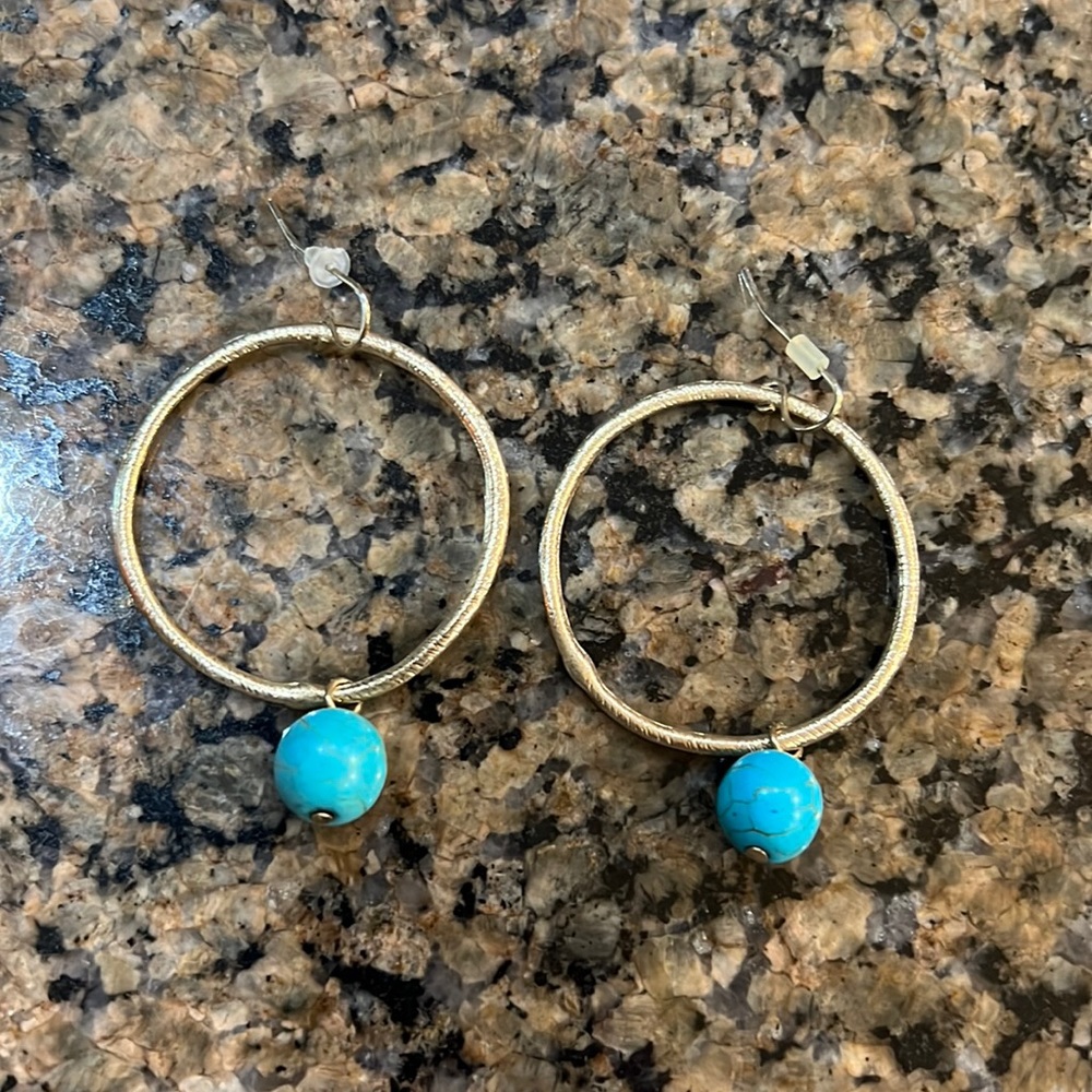 Gold tone, circular earrings with a turquoise ball at the bottom